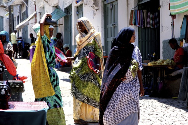 Women in Harar talking in a narrow alley, brightly dressed, Harar, Oromia, Ethiopia