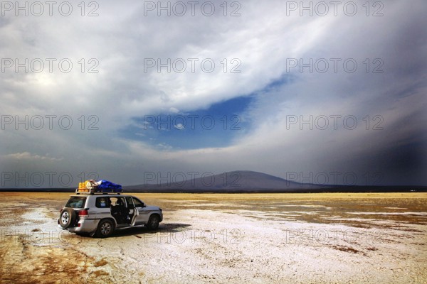 Landcruiser stands in a vast landscape with dramatic skies, zero
