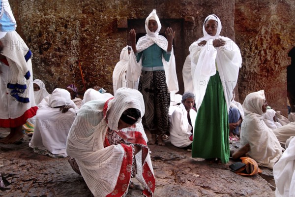 Women wearing white robes pray during Easter at Bete Maryam Church, Lalibela, Amhara, Ethiopia