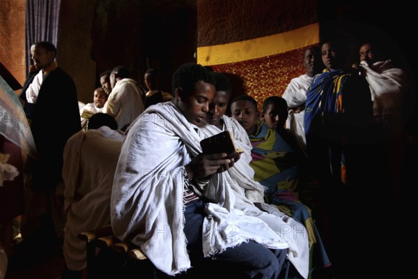 Believers read Bete Gabriel and Raphael during a service in the church, Lalibela, Amhara, Ethiopia