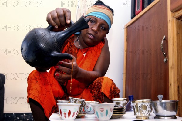 Woman performs traditional coffee ceremony during Easter, Lalibela, Ethiopia