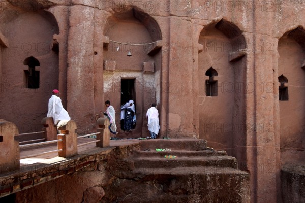 People wearing traditional clothing in the impressive Bete Gabriel Raphael Rock Church, Lalibela, Amhara, Ethiopia