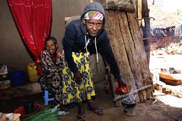 Two woman having a traditional coffee ceremony surrounded by warmth and warmth, Lalibela, Amhara, Ethiopia