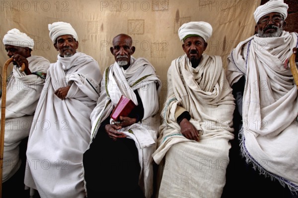 A group of priests sit during a service at Bete Maryam Church, Lalibela, Amhara, Ethiopia