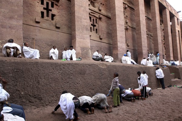 People wearing white robes pray at the Bete Medhane Alem Rock Church during Easter, Lalibela, Amhara, Ethiopia