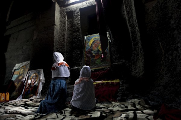 People praying in front of icons in Bete Medhane Alem, Lalibela, Amhara, Ethiopia