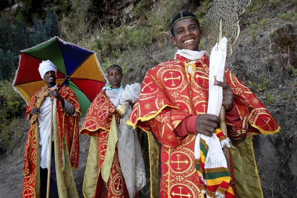 Priest in traditional red robes and colorful umbrella, Lalibela, Lasta Mountains, Ethiopia