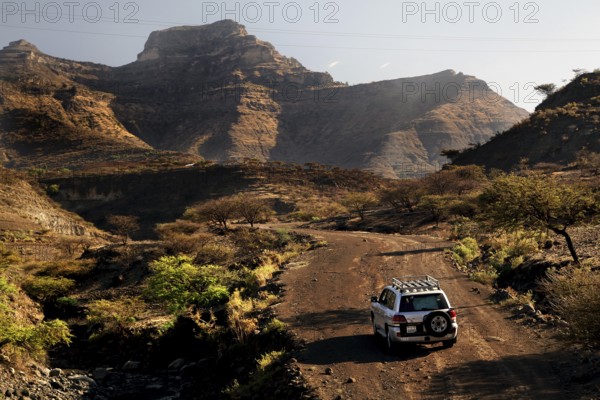 A vehicle drives on a remote road through the Lasta Mountains, Lalibela, Amhara, Ethiopia