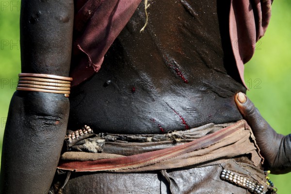 Close-up view of a Hamer initiation ritual with visible scars and traditional jewelry, Turmi, region, Ethiopia