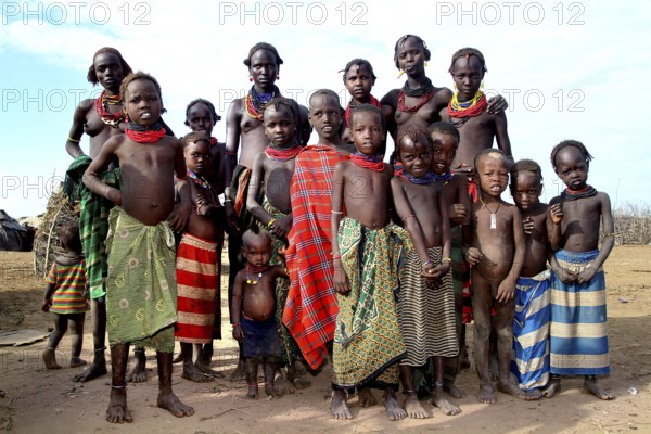 Young woman and children pose happily for a group photo in Omorate, Omorate, Ethiopia