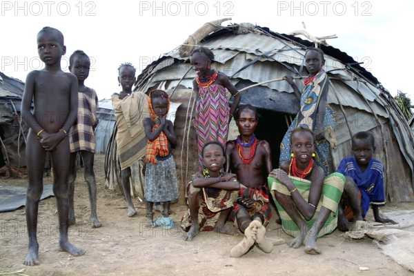 Woman and children in front of traditional huts in a village in Omorate, Omorate, Ethiopia