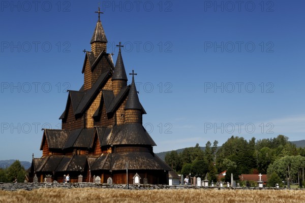 Historic stave church in Heddal with ornate wooden structure and blue sky in the background, Heddal, Norway