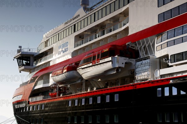 Hurtigruten ship with red and white details and lifeboats on deck