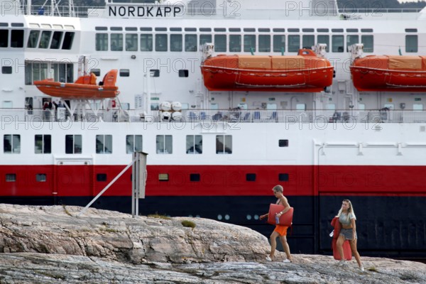 Hurtigruten ship in Kristiansund, dock with passengers and distinctive red lifeboats, Kristiansund, Norway