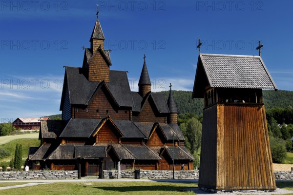 Heddal stave church with free-standing bell tower under clear sky, Heddal, Notodden, Norway