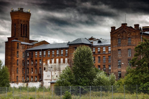 Old brick building of the Kreenholm textile factory in Narva under a threatening sky, Narva, Estonia
