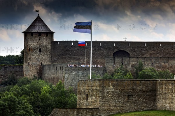 Close-up of Hermann Fortress with Estonian and Russian flags including dramatic clouds, Narva, Estonia