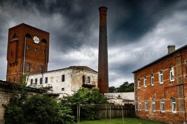 Old brick factory with tall chimney and dramatic sky in Narva, Narva, Estonia