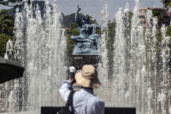 Urakami Peace Park with spray fountain and peace statue, visitors in the foreground, Nagasaki, Japan