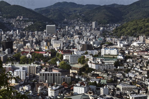 Dense city view of Nagasaki from Nakanmuriyama with mountains in the background, Nagasaki, Japan