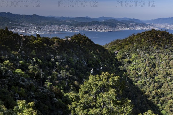 View of the forests and coastal landscape from Mount Misen with a view of Hiroshima, Miyajima, Hiroshima, Japan