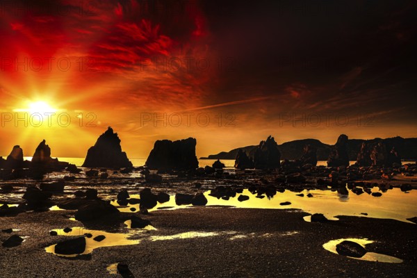 Fiery red sunrise over coastal rock formations with intense reflections, Kushimoto, Japan