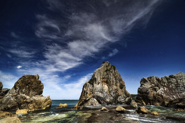 Impressive rock formations rise on the coast under a dramatic sky, Kushimoto, Wakayama, Japan