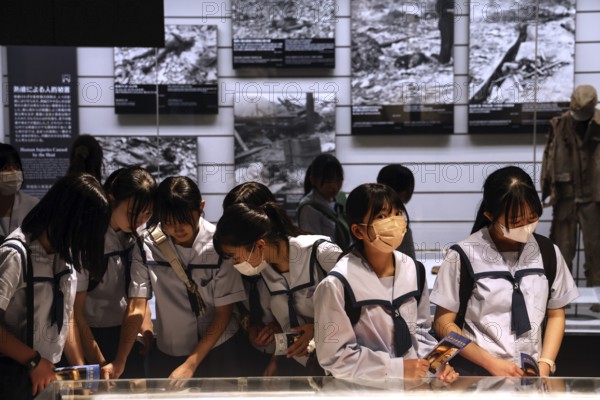 Group of students visiting the atomic bomb museum in Nagasaki, deeply immersed in the topic, Nagasaki, Kyushu, Japan