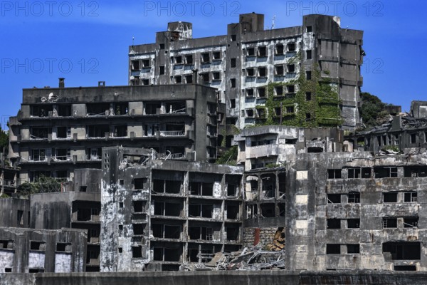 Impressive shot of Gunkanjima's crumbling urban structure seen from the sea, Nagasaki, Kyushu, Japan