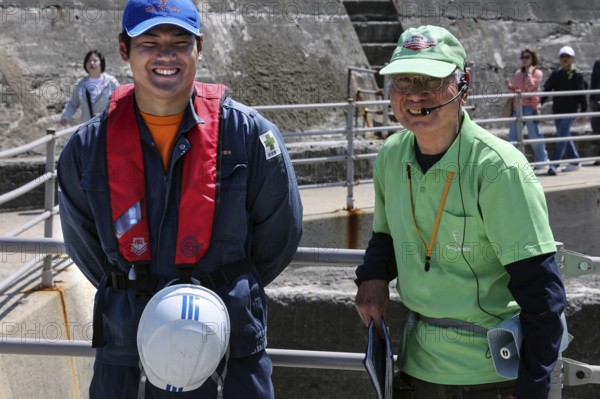 Two friendly guides during a shore trip on the deserted island of Gunkanjima, Nagasaki, Kyushu, Japan
