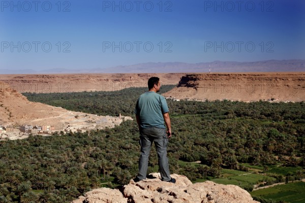 A man looks at the green palm village in the Ziz Valley, Ziz Valley, Roland