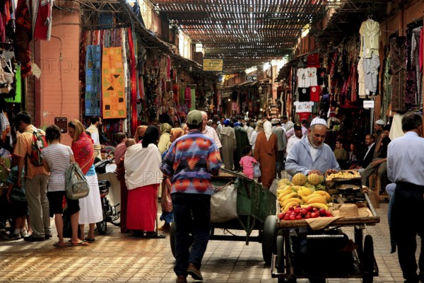 Lively souk in Marrakech with numerous people and colorful stalls, Marrakech, Morocco