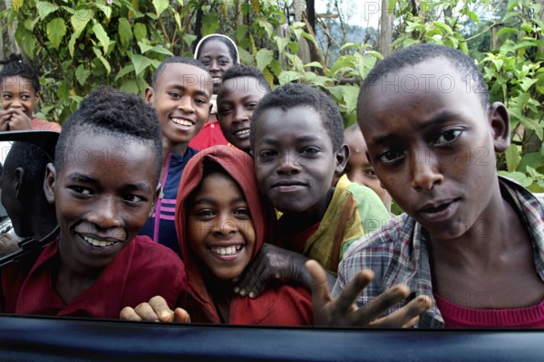 Group of kids smiling happily at the camera along the route from Yirga Alem to Yabello, Yirga Alem, Yabello, Ethiopia