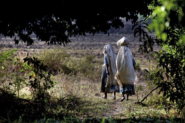 Two woman wearing traditional clothing in a natural setting, Tisissat, Ethiopia