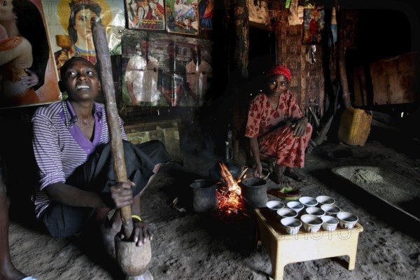 Women prepare traditional food at a fireplace in a hut, Yirga Alem, Ethiopia
