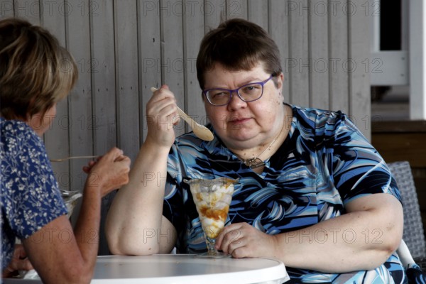 Two woman enjoying ice cream at a table in Naantali, Naantali, Finland