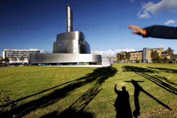 Modern Northern Lights Cathedral in Alta with long shadows on the meadow, Alta, Finnmark, Norway