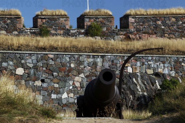 Cannon and bastion of Suomenlinna sea fortress with stone wall, Helsinki, Uusimaa, Finland
