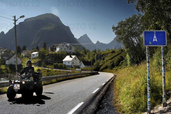 ATV on a road in Å, surrounded by the impressive mountain scenery of Lofoten, Å, Moskenesøy, Norway