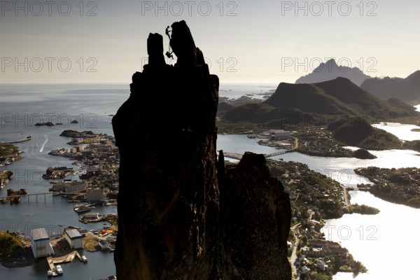 The distinctive rock pin Svolværgeita rises over an extensive coastal landscape, Svolvær, Nordland, Norway