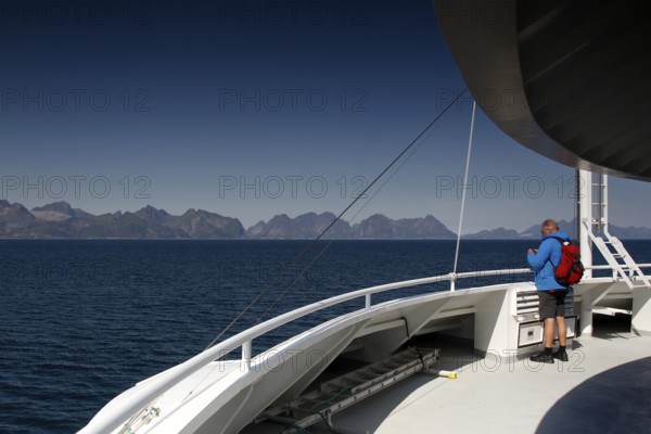 Passengers on a ferry enjoy sweeping views of the beautiful mountain scenery of Lofoten
