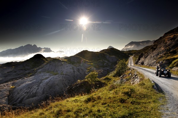 ATV rides through the rolling countryside of Lofoten under dazzling sunlight, Vestvågøy, Neslandsveien, Norway