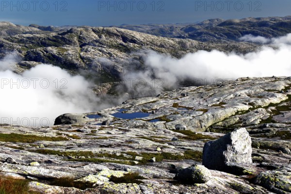 Wide plateau with clouds over a rocky landscape in Kjerag, Lysefjord, Rogaland, Norway