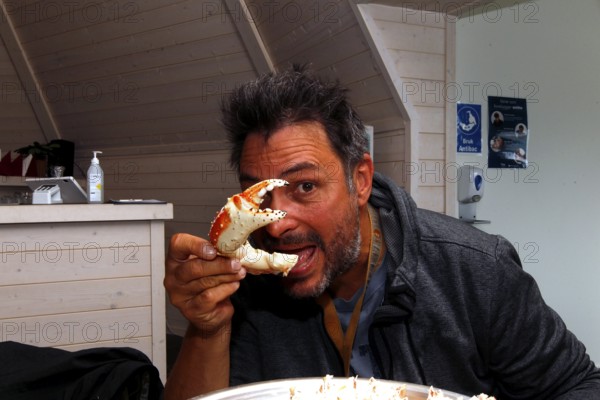 Person eats king crab in a restaurant in Sarnes, Sarnes, Norway
