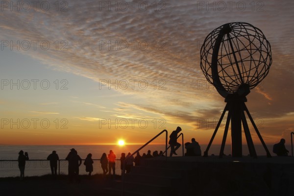 Crowd of people at the North Cape globe at a picturesque sunset, North Cape, Magerøya, Norway