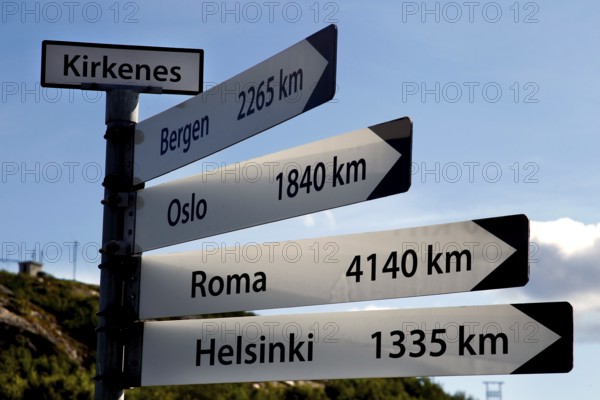 Guide in Kirkenes shows distances to various cities under blue skies, Kirkenes, Finnmark, Norway