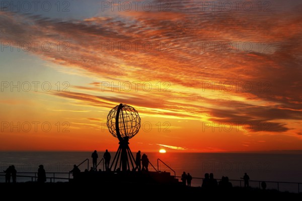 Sunset on the North Cape with colorful clouds and silhouettes in front of the globe, North Cape, Magerøya, Norway