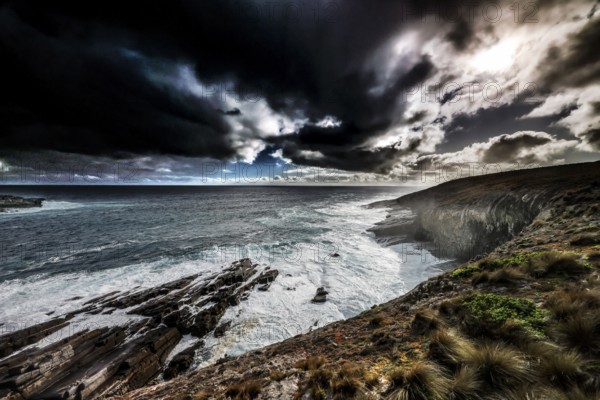 Gloomy coastal atmosphere with strong waves and dark clouds near Cape du Couedic, Kangaroo Island, South Australia, Australia