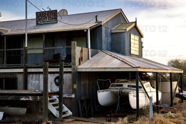 Rustic Lake Eyre Yacht Club building with moored boats in Marree, Marree, South Australia, Australia