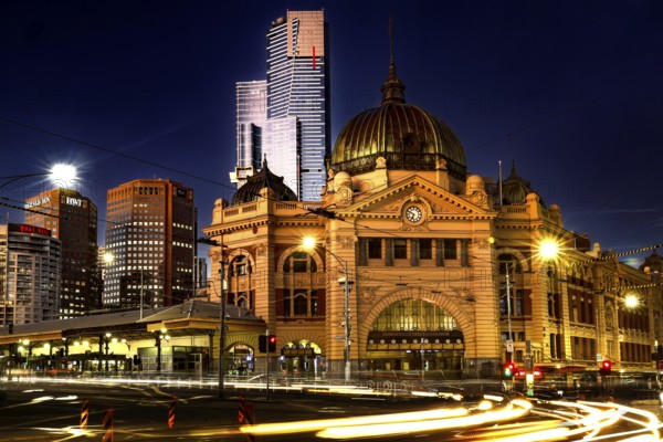 Flinders Street Station at night with magnificent lighting against an urban backdrop, Melbourne, Victoria, Australia